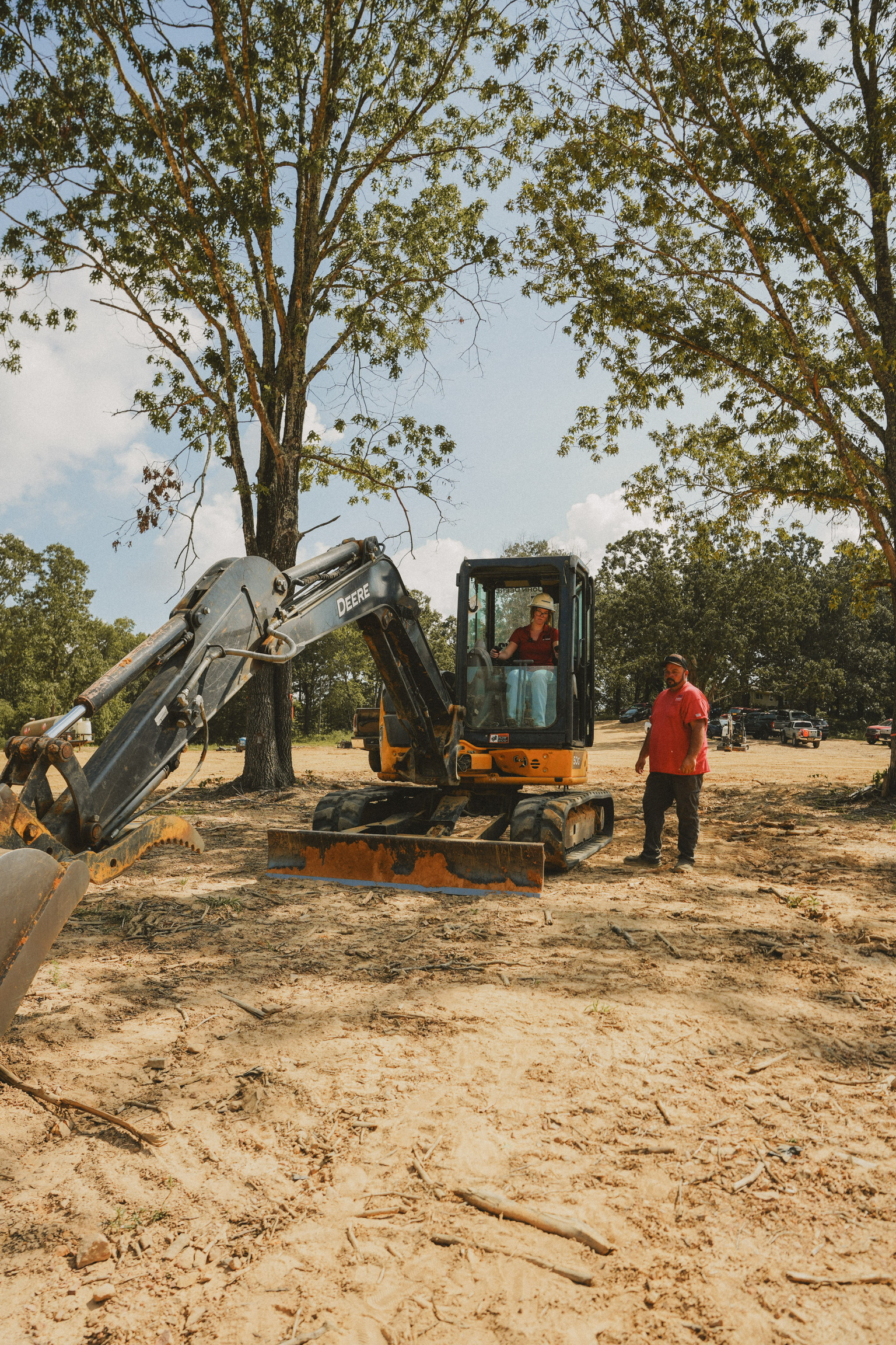 Student operating mini excavator with instructor