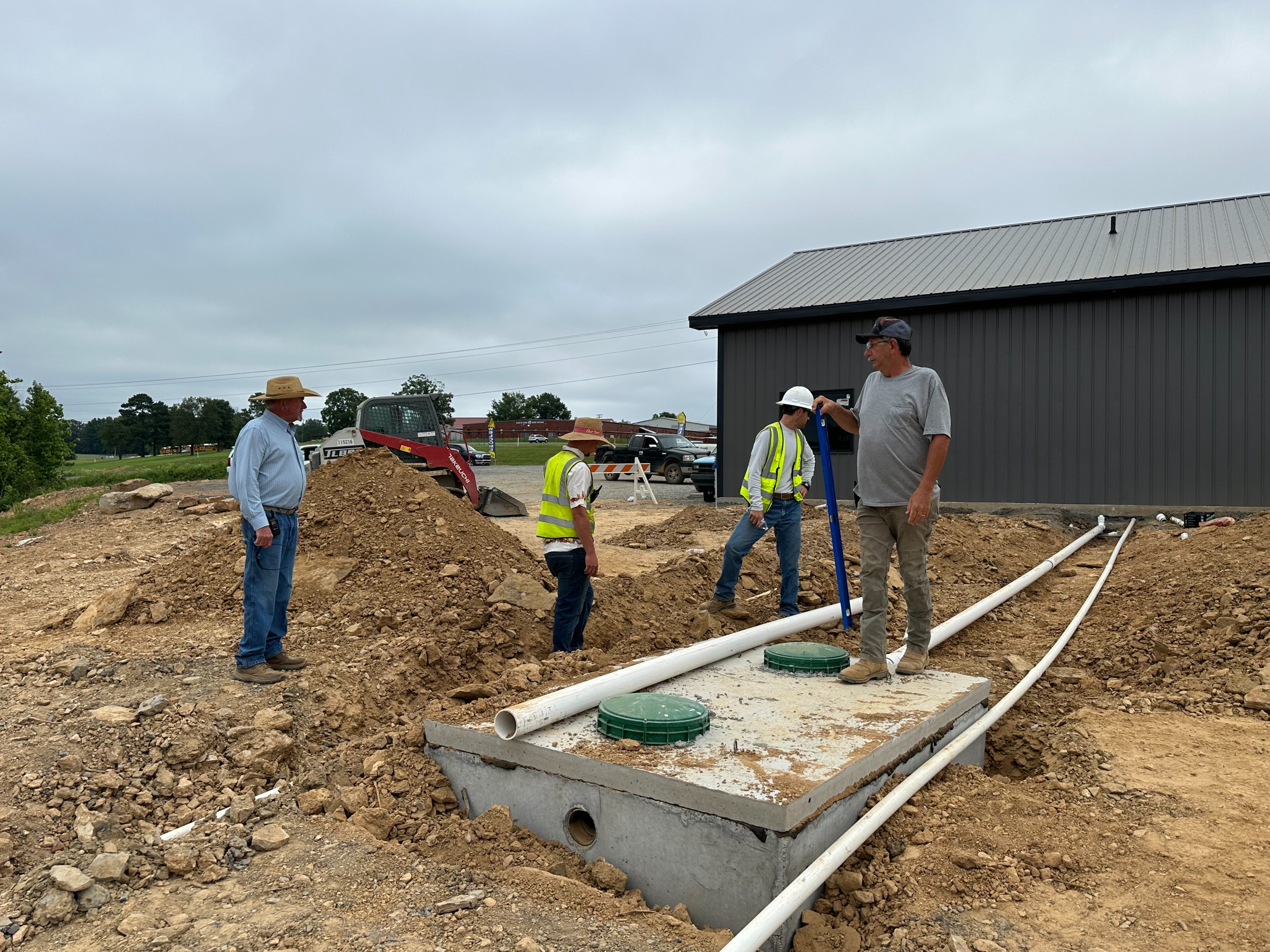 HEO Academy founder Dennis Edwards providing hands-on instruction to heavy equipment students during construction of the academy campus